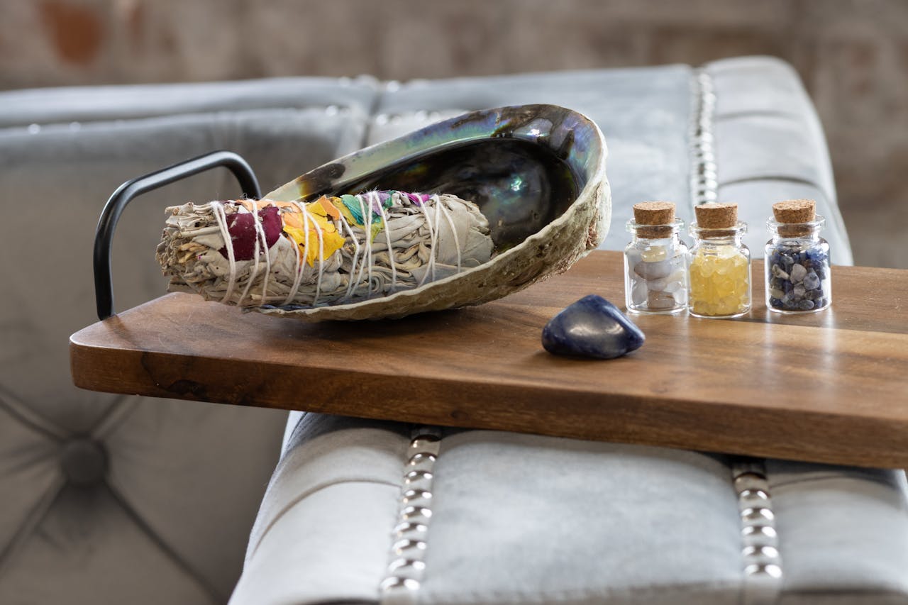 A serene setup featuring sage, crystals, and bottles for healing and energy balance.