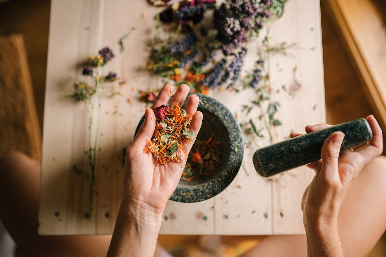 contact-img Hands grinding dried herbs with a mortar and pestle, perfect for holistic medicine and aromatherapy.