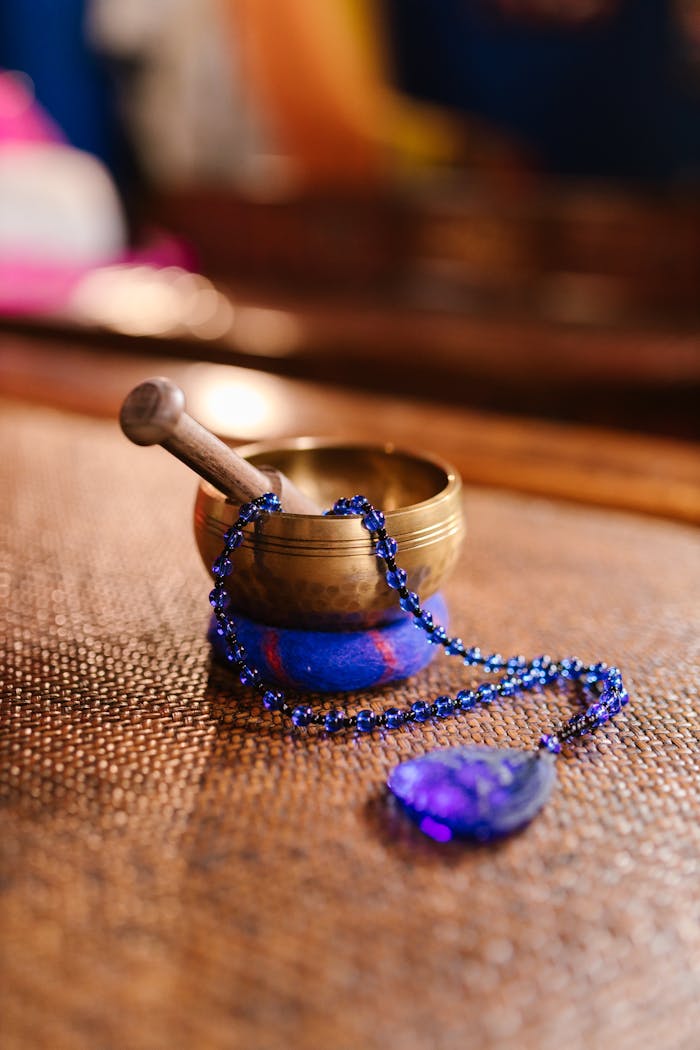 gallery-4 A serene setup of a Tibetan singing bowl and prayer beads for meditation and relaxation.